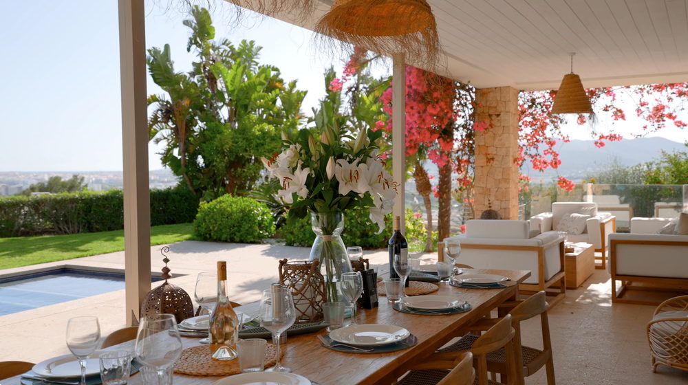 Terraza de un restaurante con mesas puestas y vistas al mar