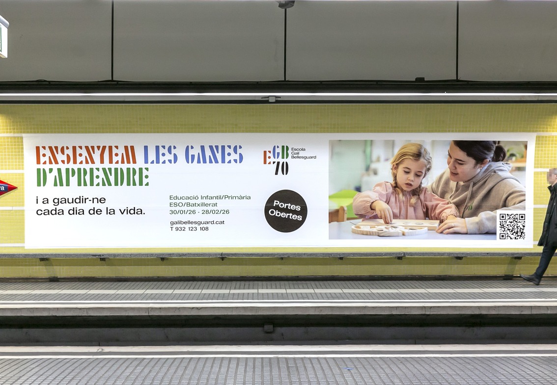 Lona de la campaña en el andén de una estación de metro, con un viajero pasando por delante