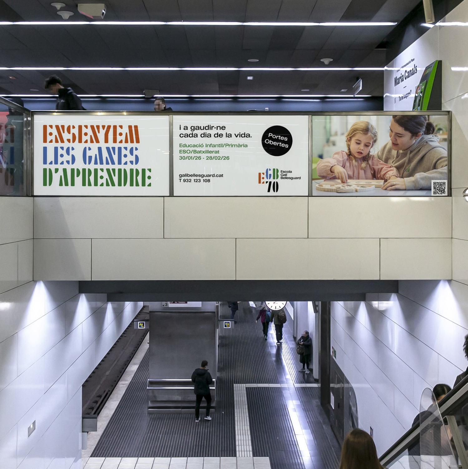 Vestíbulo de metro con dos lonas de la campaña sobre las escaleras de acceso