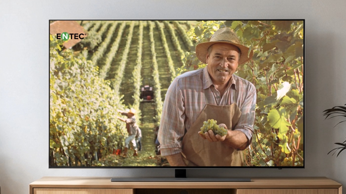 Televisor de salón emitiendo el anuncio de EuroChem con un agricultor en un viñedo