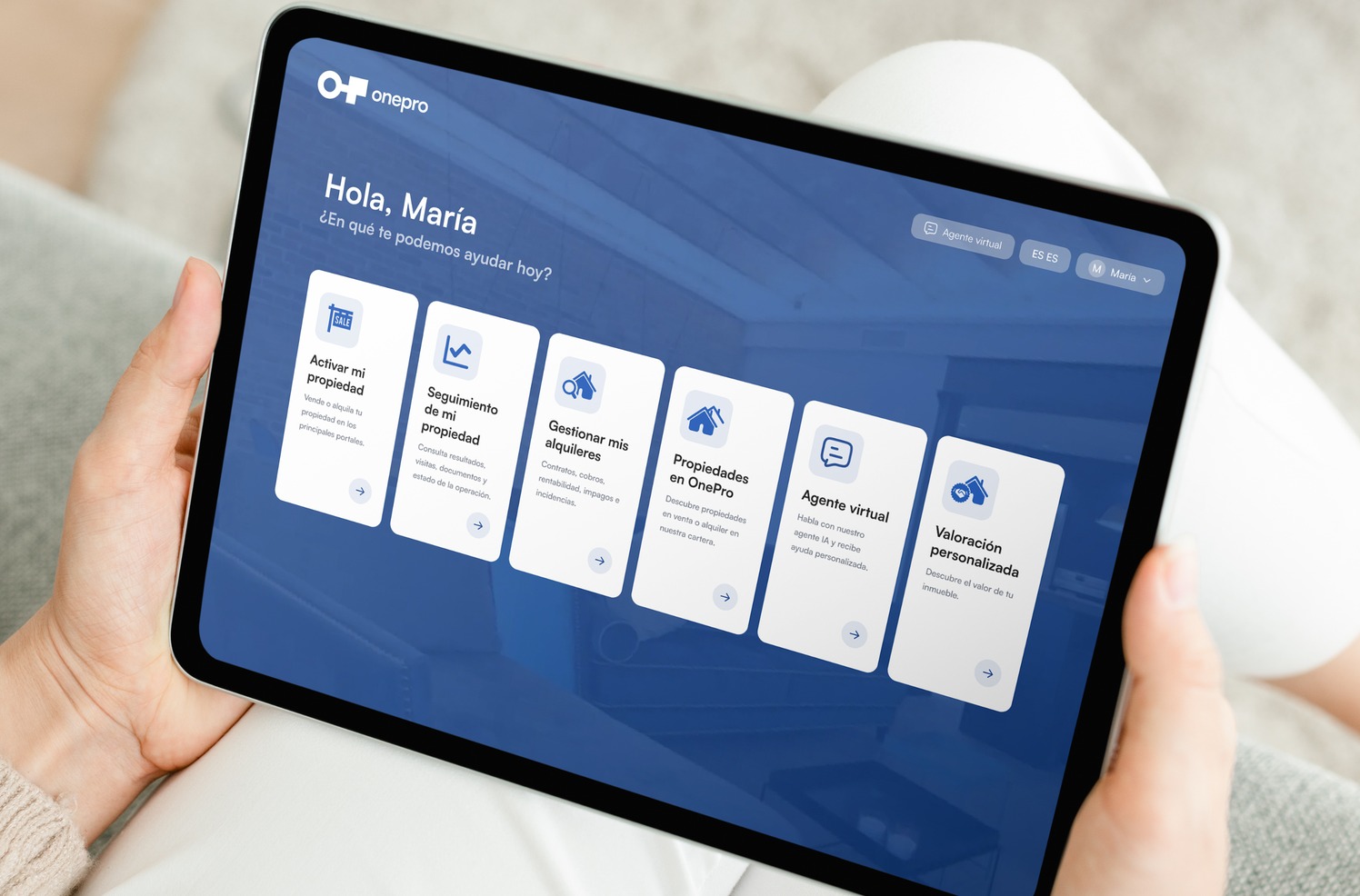 Una persona usa la WebApp de OnePro en una tableta, con el panel «Hola, María»